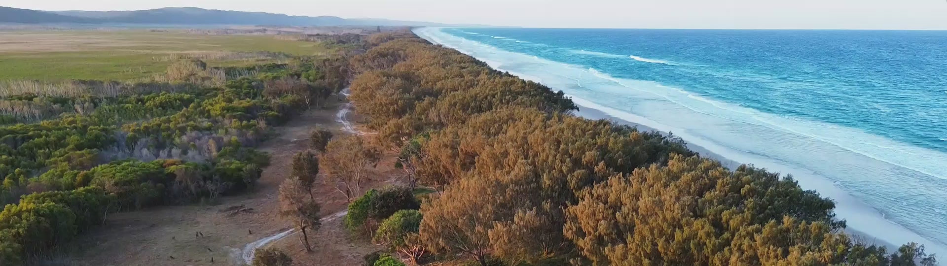 Load video: Epic drone footage over the ocean descending into the dunes to a Lanzerac Outdoors RapidPack pop out tent.